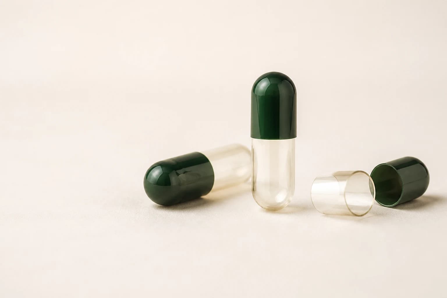 Empty HPMC capsules with forest-green caps and translucent plant-cellulose bodies
