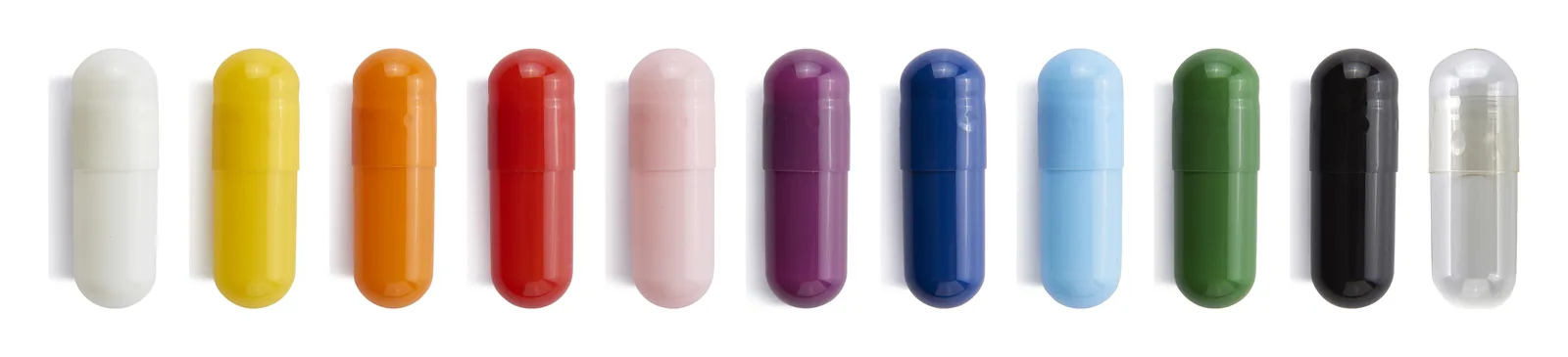 Eleven photographed capsule colours in a row, including white, yellow, orange, red, pink, purple, blue, green, black and clear.