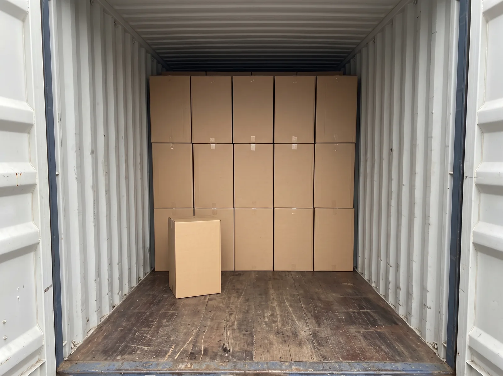 Cartons stacked inside a shipping container.